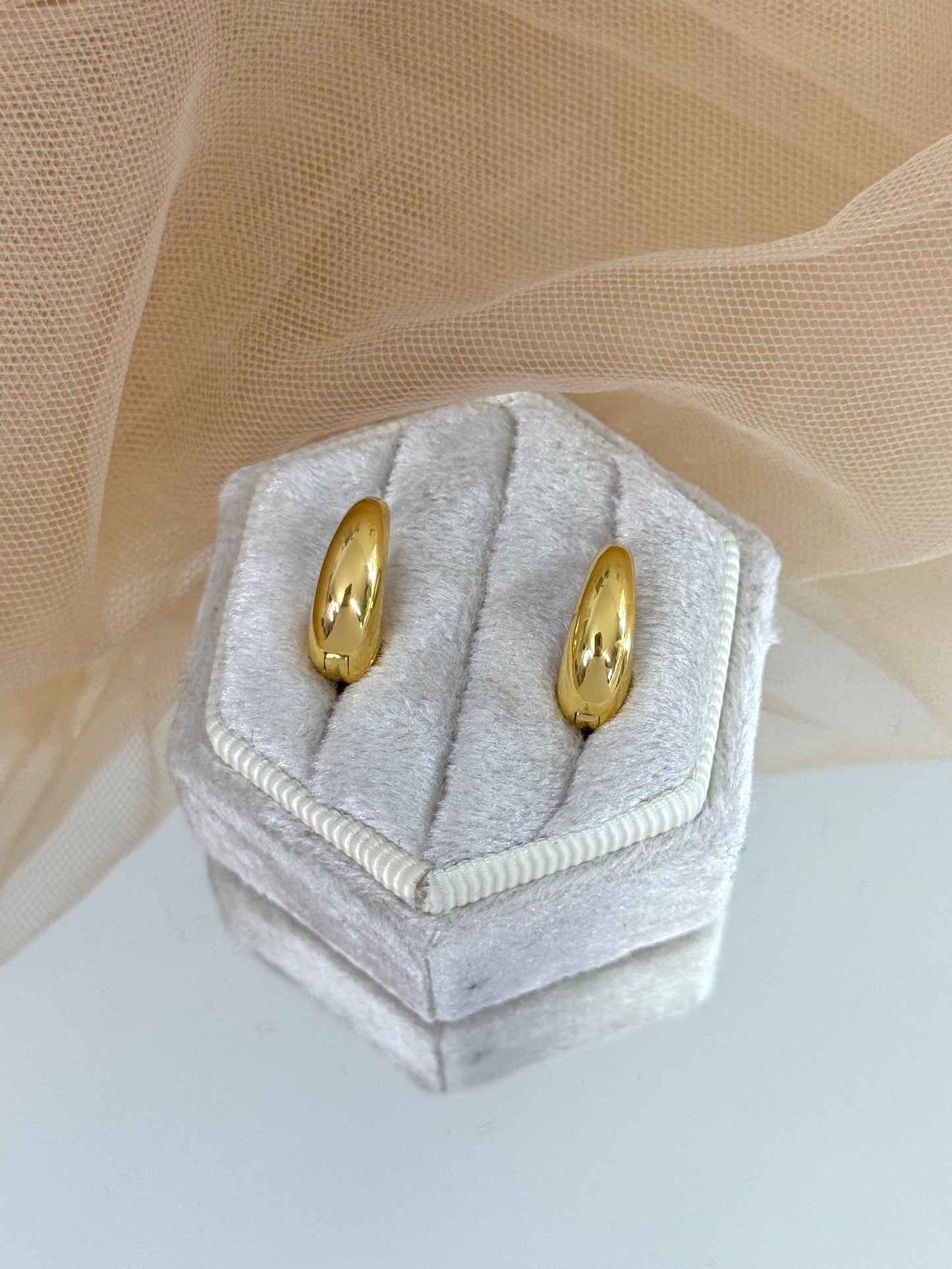 Gold hoop earrings in a hexagonal gray velvet box on a beige fabric background, hoop earrings, minimalist look, everyday wear, perfect gift for her