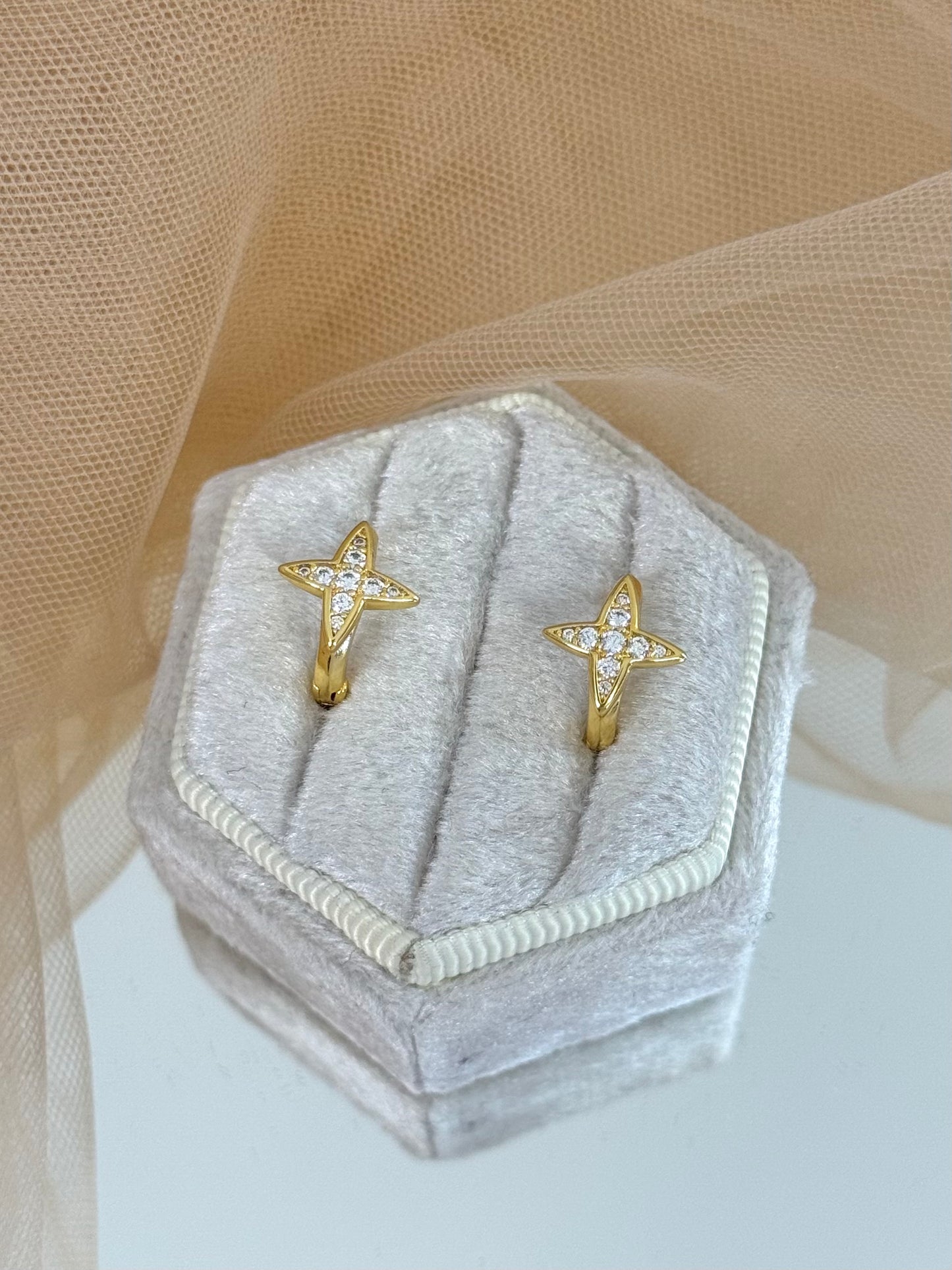 Gold star-shaped earrings in a hexagonal gray velvet box on a beige fabric background, stud earrings, anniversary gift for her, minimalist look, elegant drop earring, everyday wear