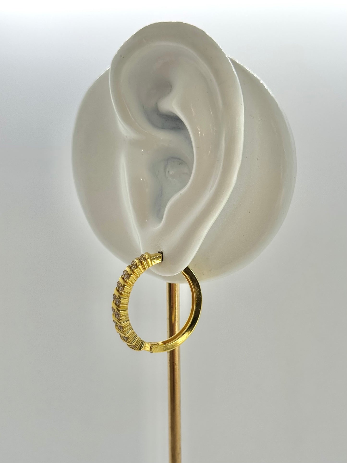 Gold hoop earrings on a hexagonal gray stone with a beige fabric background, hoop earrings, hoops, everyday wear, unique design
