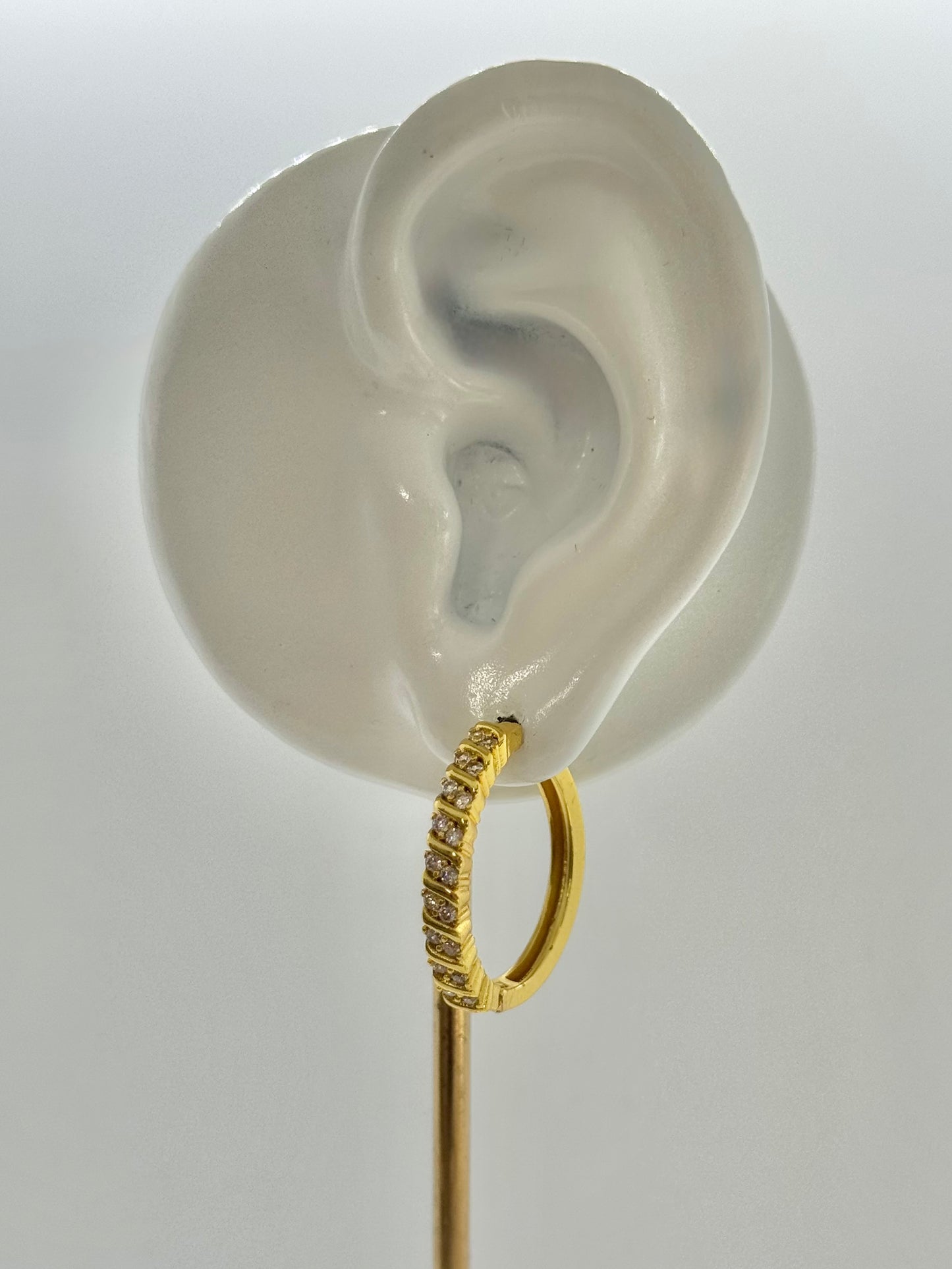 Gold hoop earrings on a hexagonal gray stone with a beige fabric background, hoop earrings, hoops, everyday wear, unique design
