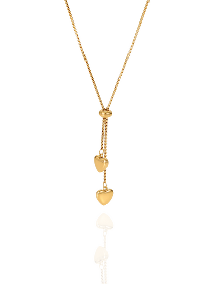 Gold necklace with heart-shaped pendants on a white background, heart pendants, partridge eye chain, minimalist necklace, formal wear, everyday wear, delicate gold heart charm