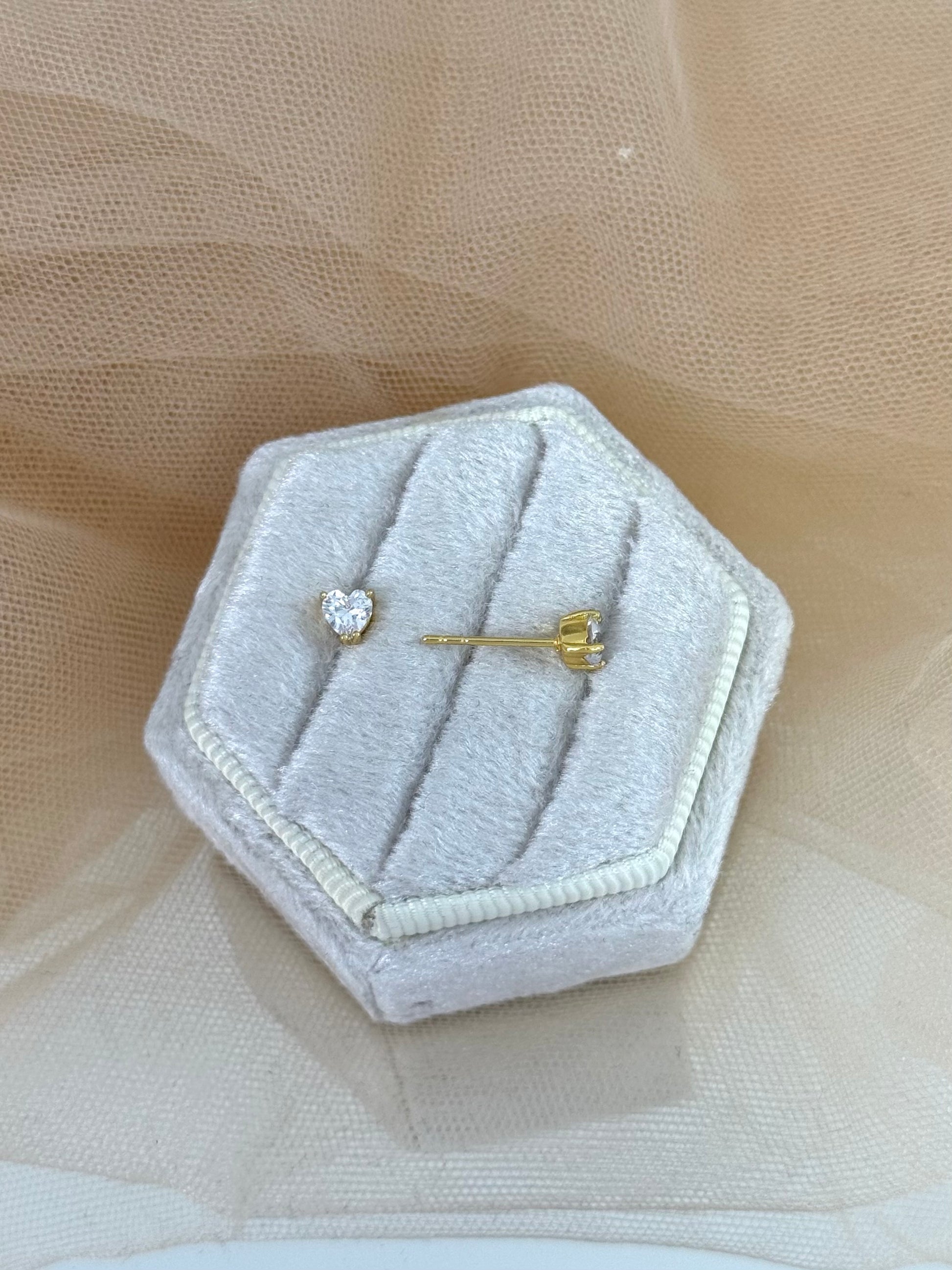 Hexagonal gray jewelry box with heart-shaped earrings on a beige fabric background, perfect gift for her, heart shaped, heart stud earrings, stud earrings, timeless, classy look, everyday wear