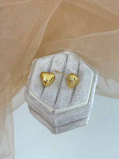 Gold heart-shaped earrings in a hexagonal gray velvet box with beige fabric background, stud earrings, elegant studs, timeless, anniversary gift, everyday wear