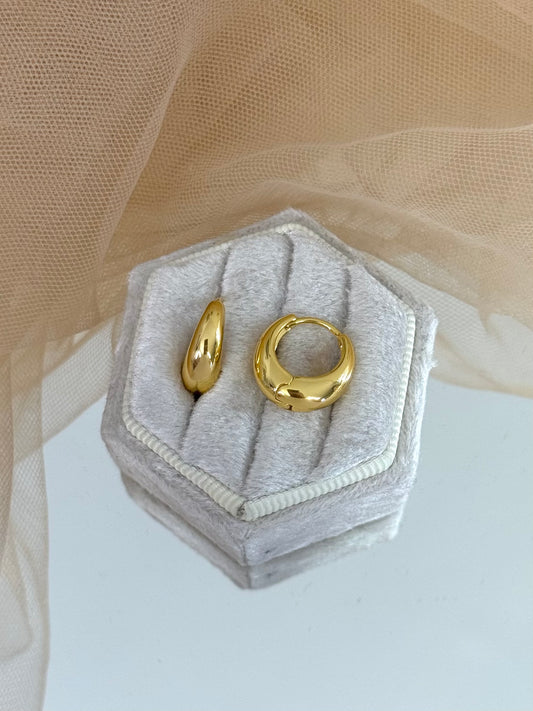 Gold hoop earrings in a hexagonal gray velvet box on a beige fabric background, hoop earrings, minimalist look, everyday wear, perfect gift for her