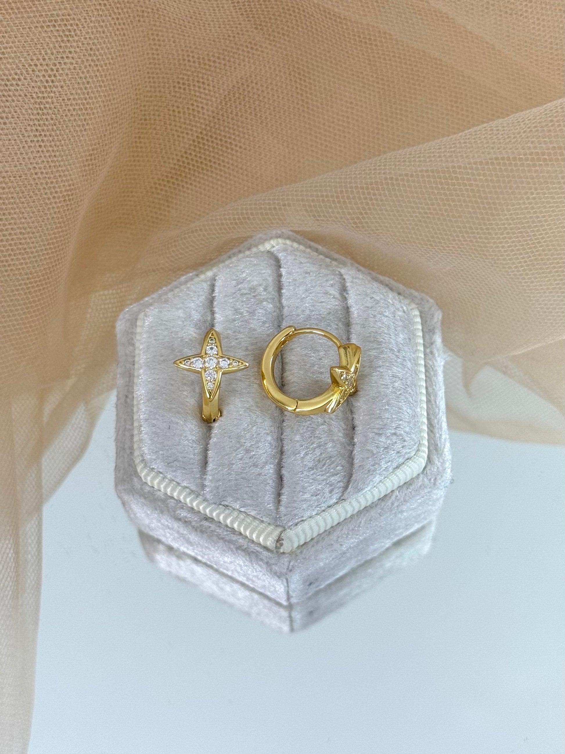 Gold star-shaped earrings in a hexagonal gray velvet box on a beige fabric background, stud earrings, anniversary gift for her, minimalist look, elegant drop earring, everyday wear
