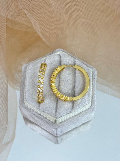 Gold hoop earrings on a hexagonal gray stone with a beige fabric background, hoop earrings, hoops, everyday wear, unique design