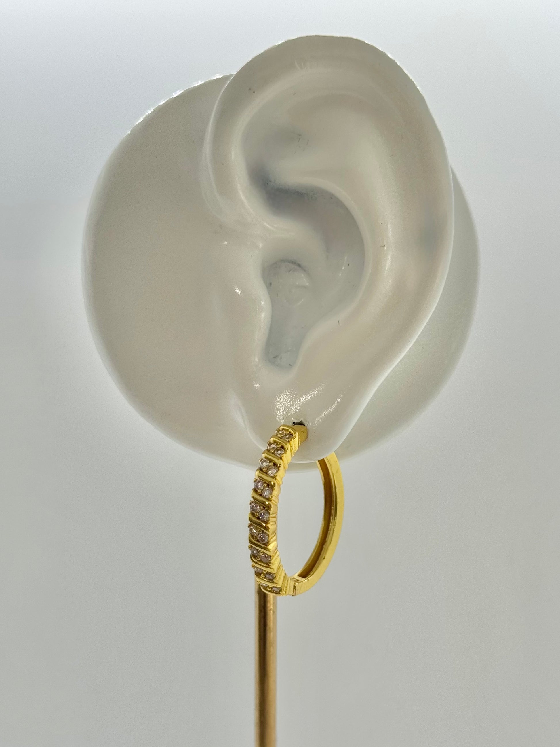 Gold hoop earrings on a hexagonal gray stone with a beige fabric background, hoop earrings, hoops, everyday wear, unique design